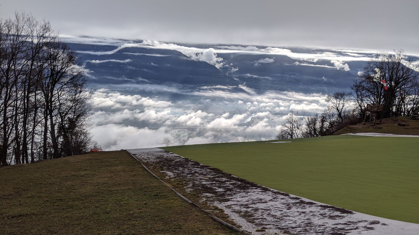 Mer de nuages débordant sur un atterrissage de parapente