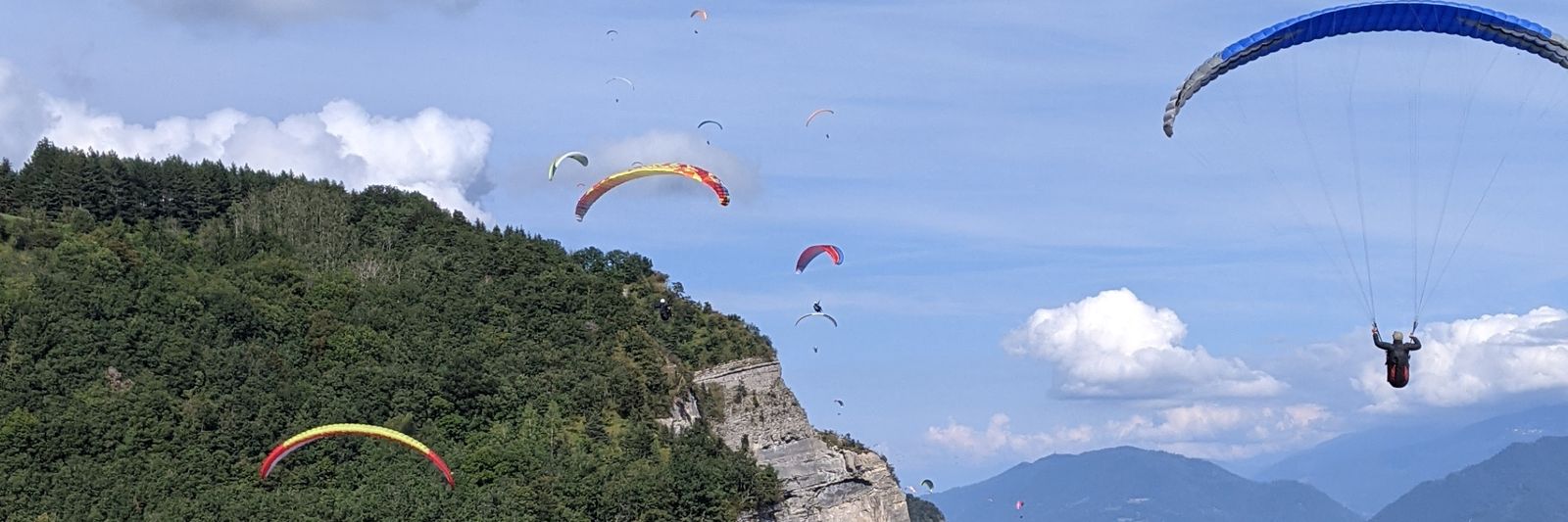 Ailes de parapente en vol le long d'une falaise